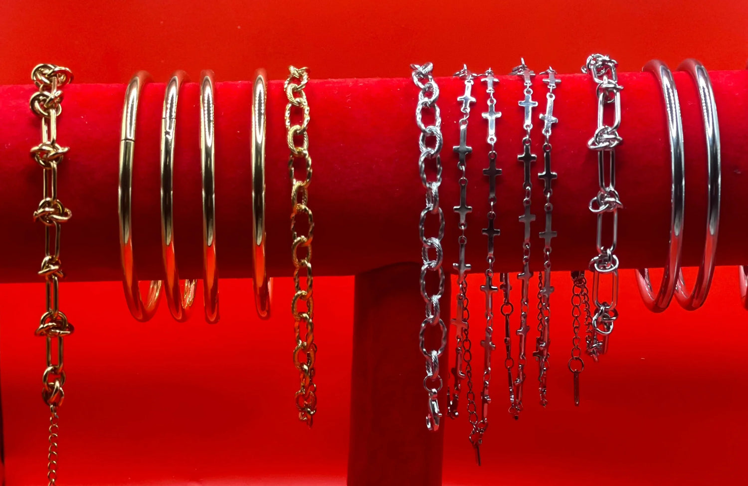 Bracciali in acciaio inossidabile oro e argento su supporto rosso, gioielli LUEUR moderni.