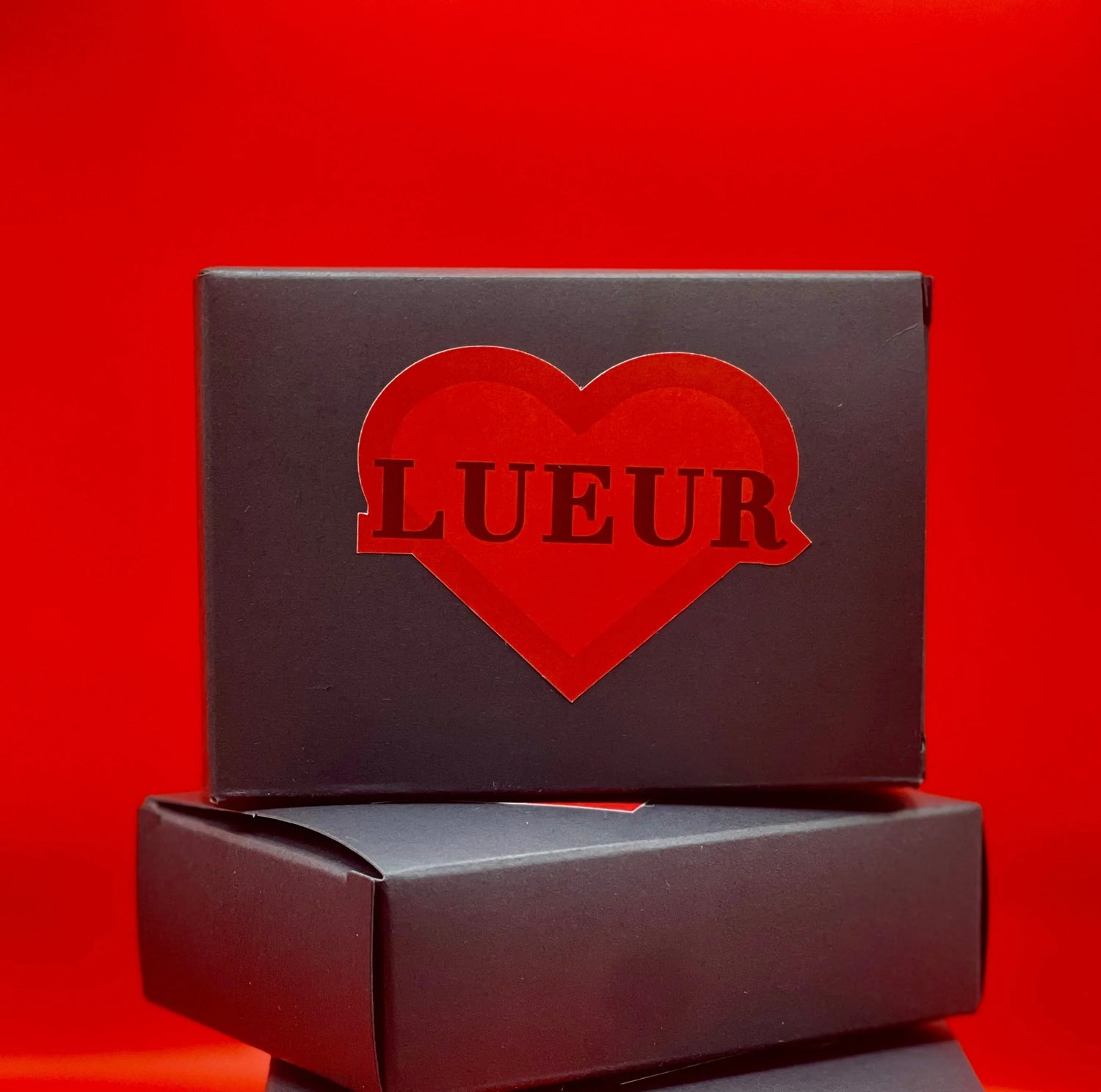 Scatola nera LUEUR per gioielli artigianali, con cuore rosso su sfondo rosso.